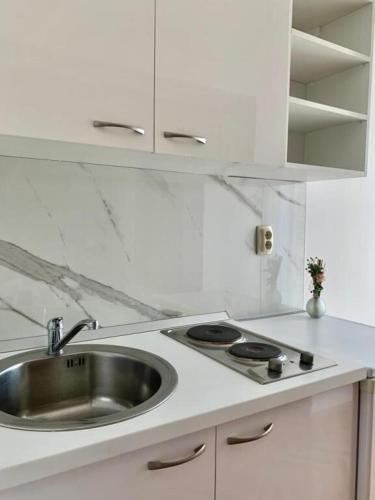 a white kitchen with a sink and a stove at Apartments and Rooms Nikola in Omiš