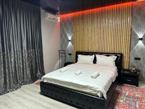a bedroom with a large bed with two phones on it at Гостевой дом на Коктобе Люкс 4 in Almaty