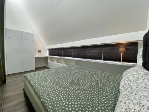 a white bedroom with a bed and a window at Departamento duplex diseño exclusivo in Huancayo
