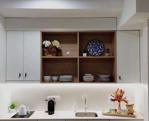 a kitchen with white cabinets and a sink and plates at Cordvba Osario Centro in Córdoba