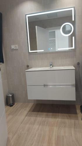 a bathroom with a white sink and a mirror at Luxury Apartment in Casilla de Costa - Casa MEVA in Lajares
