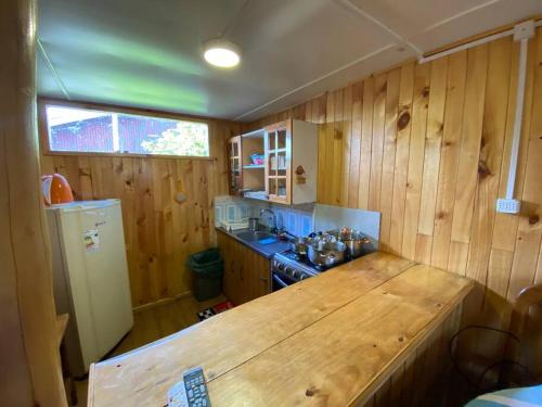 eine Küche mit Holzwänden und einer Holzoberfläche in der Unterkunft Cabañas León in Ancud