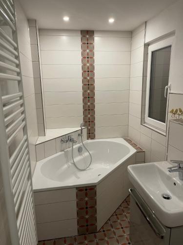a white bathroom with a tub and a sink at Altes Fischerhaus in Binz in Binz