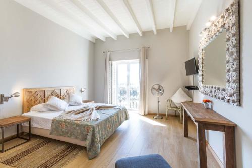 a bedroom with a bed and a table and a mirror at Villa Ataboeira in Guia