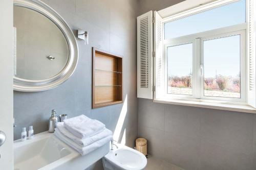 a bathroom with a sink and a toilet and a mirror at Villa Ataboeira in Guia