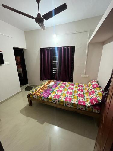 Ce lit se trouve dans un dortoir doté d'un ventilateur de plafond. dans l'établissement Lakshmi Homestay, à Alappuzha
