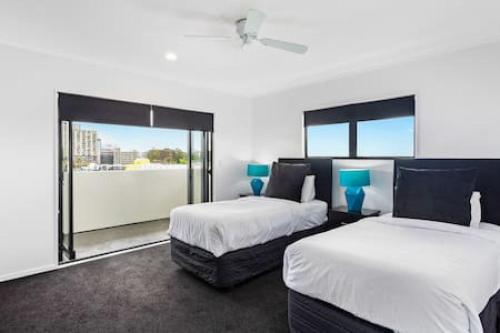 a bedroom with two beds and a large window at Freeman Escape with garage parking in Auckland