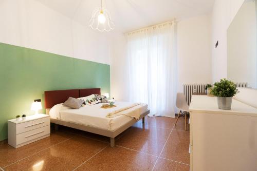 a bedroom with a bed and a green wall at Realkasa Kharkov Apartment in Bologna