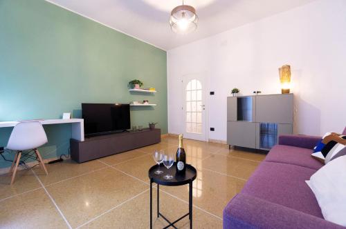 a living room with a purple couch and a table at Realkasa Kharkov Apartment in Bologna