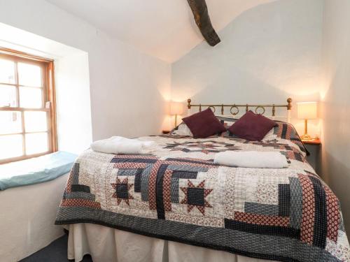 a bedroom with a bed with a quilt on it at Castle Lodge in Keswick