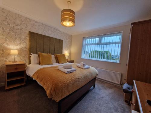 a bedroom with a large bed with towels on it at Sea Roke in Filey