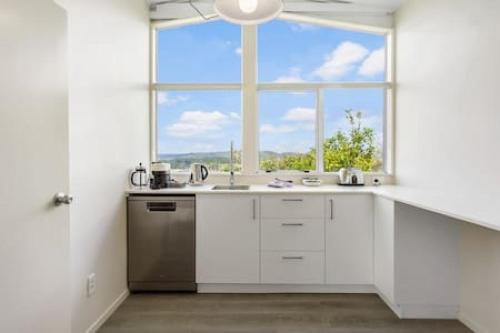 a kitchen with a sink and a large window at Serene Breeze Escape with estuary view in Whitford