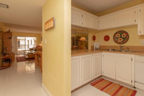 a large kitchen with white cabinets and a sink at Palms 404 in Islamorada