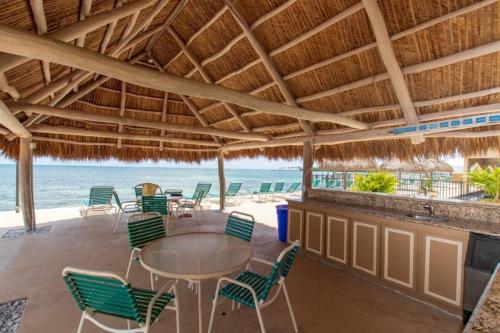 a patio with a table and chairs and the ocean at Palms 404 in Islamorada