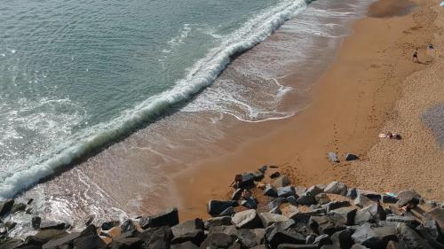 an aerial view of a beach with rocks and the ocean at Westpoint Dog Friendly Apartments in West Bay
