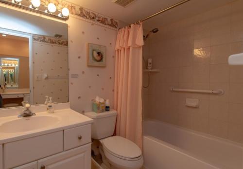 a bathroom with a toilet and a sink and a shower at Palms 407 in Islamorada