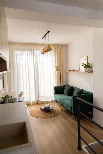 un salon avec un canapé vert et une table dans l'établissement Studio 8 I One Bedroom Apartment I Airport I Therme, à Otopeni