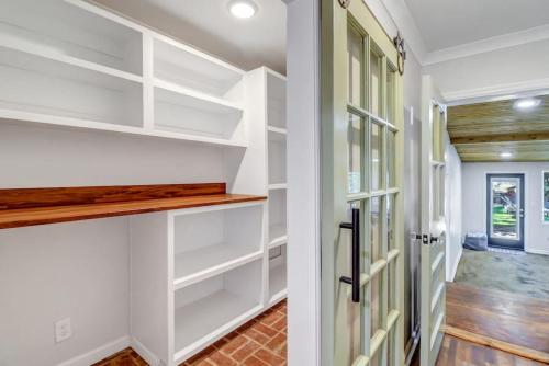 a walk in closet with white shelves and a door at Luxury Savannah Retreat Heated Pool and Pet Friendly in Savannah