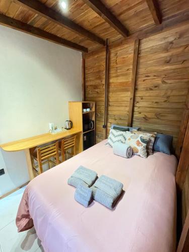 a bedroom with a bed with three towels on it at Pousada Doce Aconchego - Grão Pará - Aiurê in Aiuré