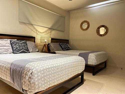 a bedroom with two beds and a mirror on the wall at Habitación Privada Riviera Maya, Playa del Carmen! in Playa del Carmen