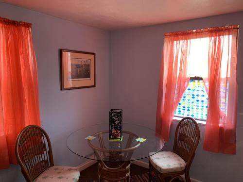 a dining room with a glass table and chairs at Break Side Studio #5 apts in North Camellia Acres