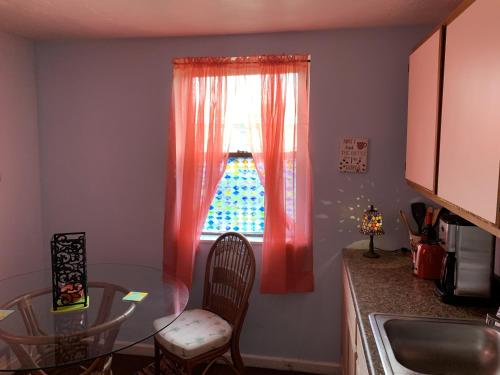 a kitchen with a glass table and a window at Break Side Studio #5 apts in North Camellia Acres
