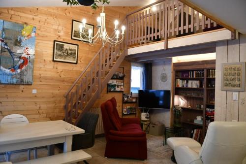 een woonkamer met een trap in een huis bij Le Cincle in La Bresse