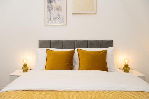 a bedroom with a white bed with yellow pillows at Modern, Stylish, cosy, Finchley London 3 Bed 2 bath Apartment with Free Parking in Whetstone
