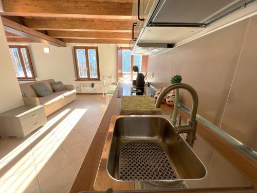 a kitchen with a sink and a living room at Affittimoderni Ponte di Legno Ski - PDL23 in Ponte di Legno
