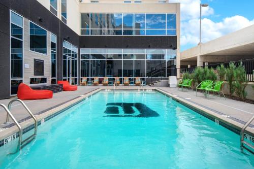 a swimming pool in front of a building at Aloft Oklahoma City Downtown – Bricktown in Oklahoma City