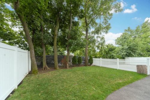 a white fence in a yard with trees at Ultra-Luxurious Home near Boston (Pet-Friendly) in Waltham