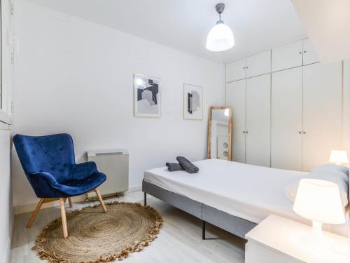 a bedroom with a bed and a blue chair at apartamento cava baja in Madrid