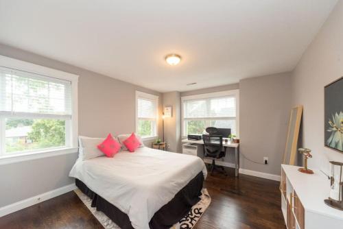 um quarto com uma cama com almofadas vermelhas e uma secretária em Ultra-Luxurious Home near Boston (Pet-Friendly) em Waltham