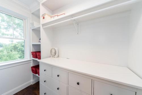 ウォルサムにあるUltra-Luxurious Home near Boston (Pet-Friendly)の白いキャビネットと窓付きのキッチン