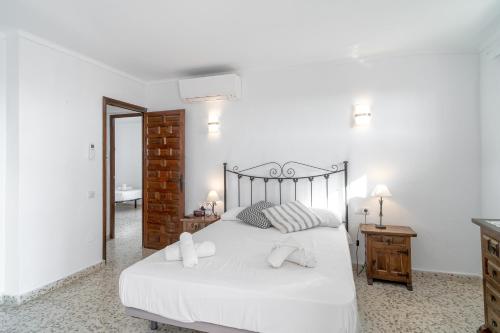 - une chambre avec un lit blanc et une table en bois dans l'établissement Via Romana 87 Villas Casasol, à Nerja
