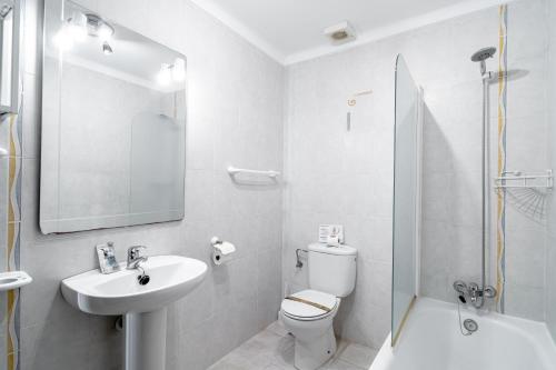 La salle de bains blanche est pourvue d'un lavabo et de toilettes. dans l'établissement Via Romana 87 Villas Casasol, à Nerja