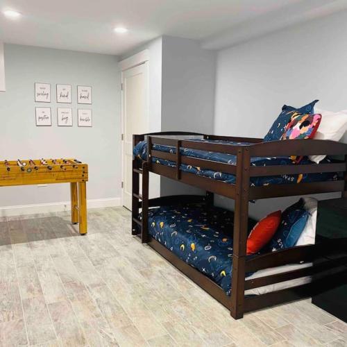 a room with two bunk beds and a table at Ultra-Luxurious Home near Boston (Pet-Friendly) in Waltham