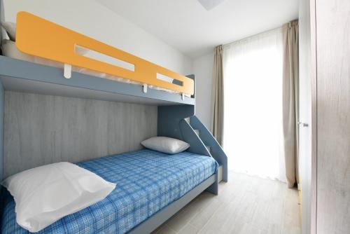 een slaapkamer met een stapelbed en een blauw bed bij Wave Plus Apartments in Lido di Jesolo