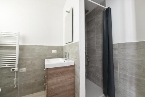 een badkamer met een wastafel en een douche bij Wave Plus Apartments in Lido di Jesolo