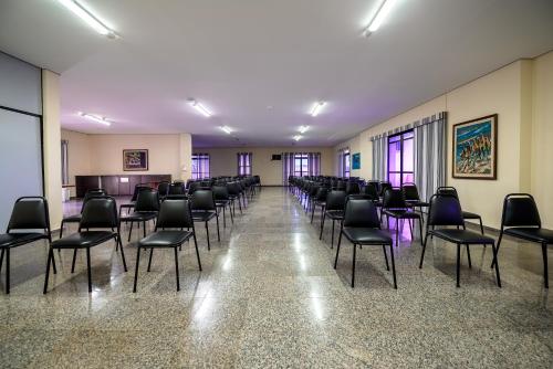 a large room with chairs and a waiting room at Rovi Plaza Hotel in Serra Negra