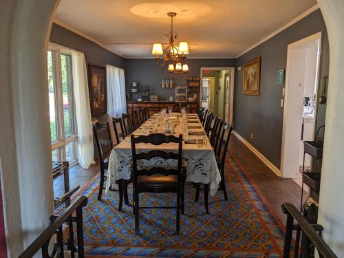 a dining room with a long table and chairs at The Oaks B&B Hotel and Spiritual Center in Jamestown