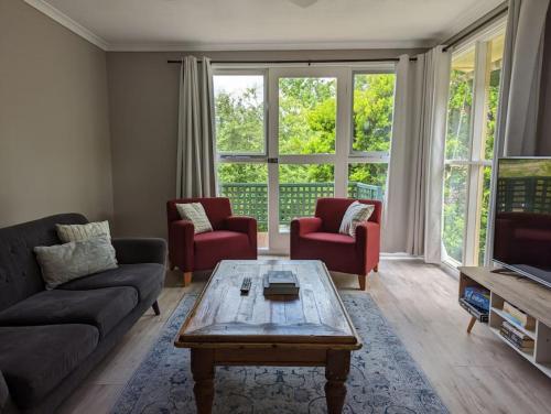 a living room with a couch and a coffee table at Happy Spacious Home nr Canberra Hospital in Harman