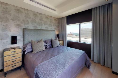 um quarto com uma cama grande e uma janela em Luxury City Living - 2 Bedroom Apartment na Cidade do Cabo