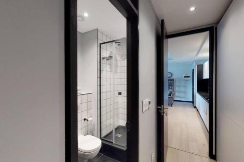 a bathroom with a toilet and a glass door at Luxury City Living - 2 Bedroom Apartment in Cape Town