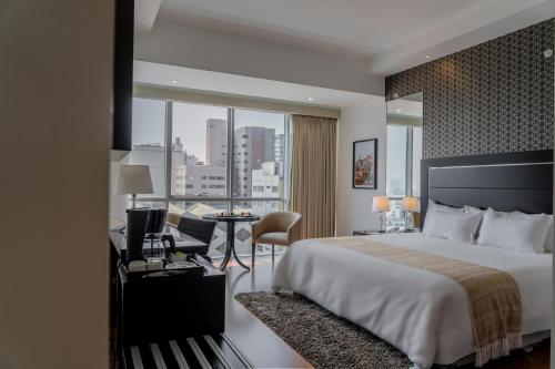 Habitación de hotel con cama grande y escritorio. en Jose Antonio Deluxe, en Lima