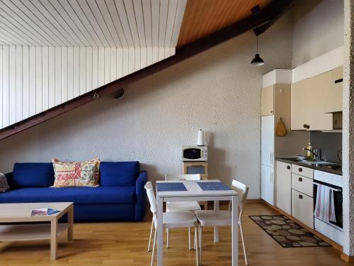 a living room with a blue couch and a table at Studio au centre de Genève in Geneva