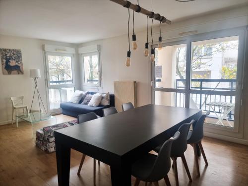 a living room with a black table and chairs at EXIGEHOME-Beautiful apartment, 2 bedrooms 70m2 15 min from Paris in Rueil-Malmaison
