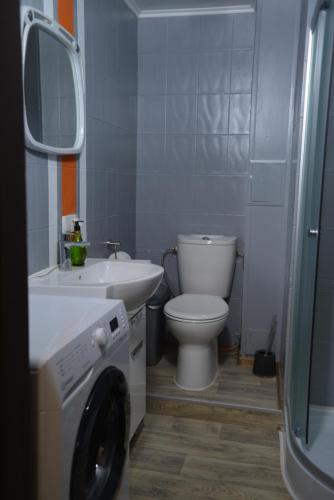 a bathroom with a toilet and a sink and a washing machine at Uneed Rooms - Cloud 9 in Kyiv