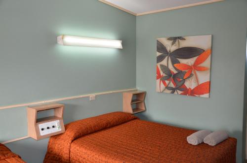 a bedroom with a bed and a picture on the wall at Warwick Motor Inn in Warwick