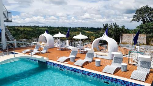 una terraza con sillas y una piscina en EliJosh Resort and Events Place, en Silang